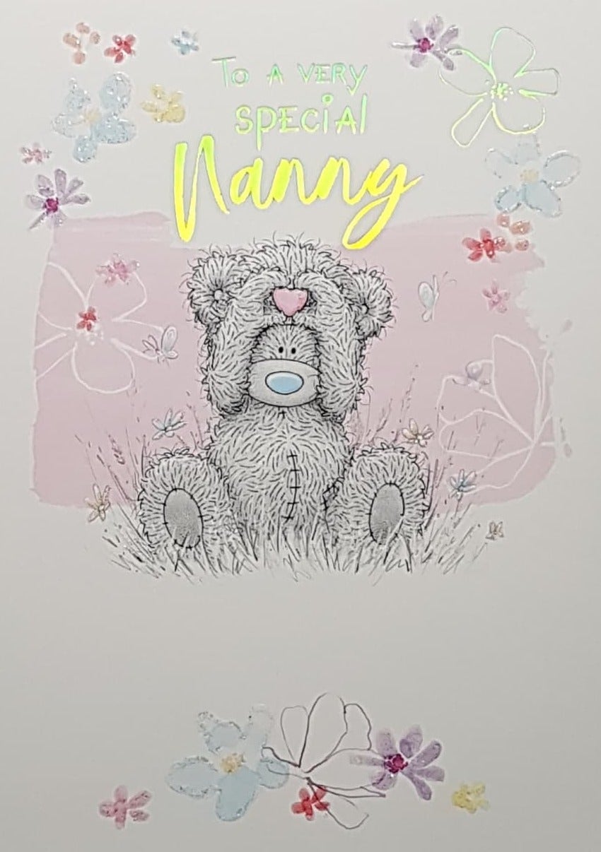 Birthday Card - Nanny / Teddy Bear Sitting On The Grass Holding A Pink Heart