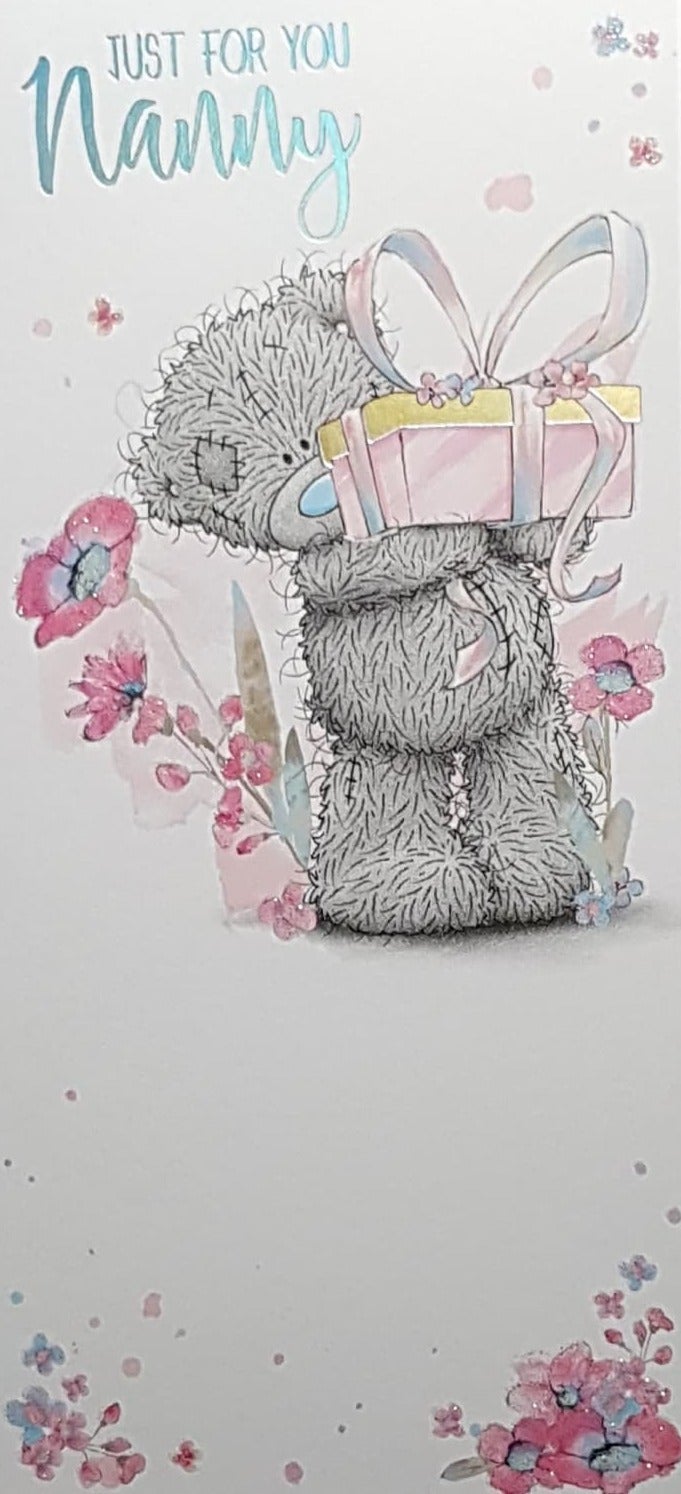 Birthday Card - Nanny / Teddy Carrying A Pink Gift With A Bow Near Pink Flowers